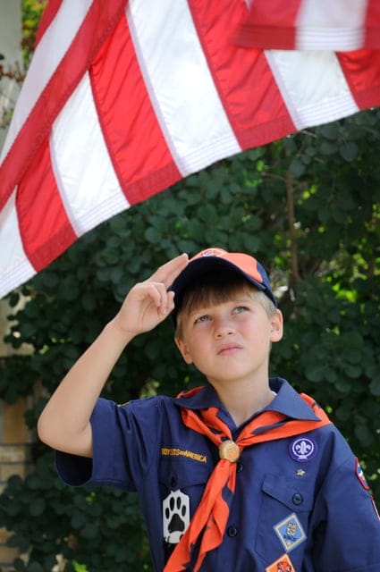 Tiger cub scout saluting the American flag