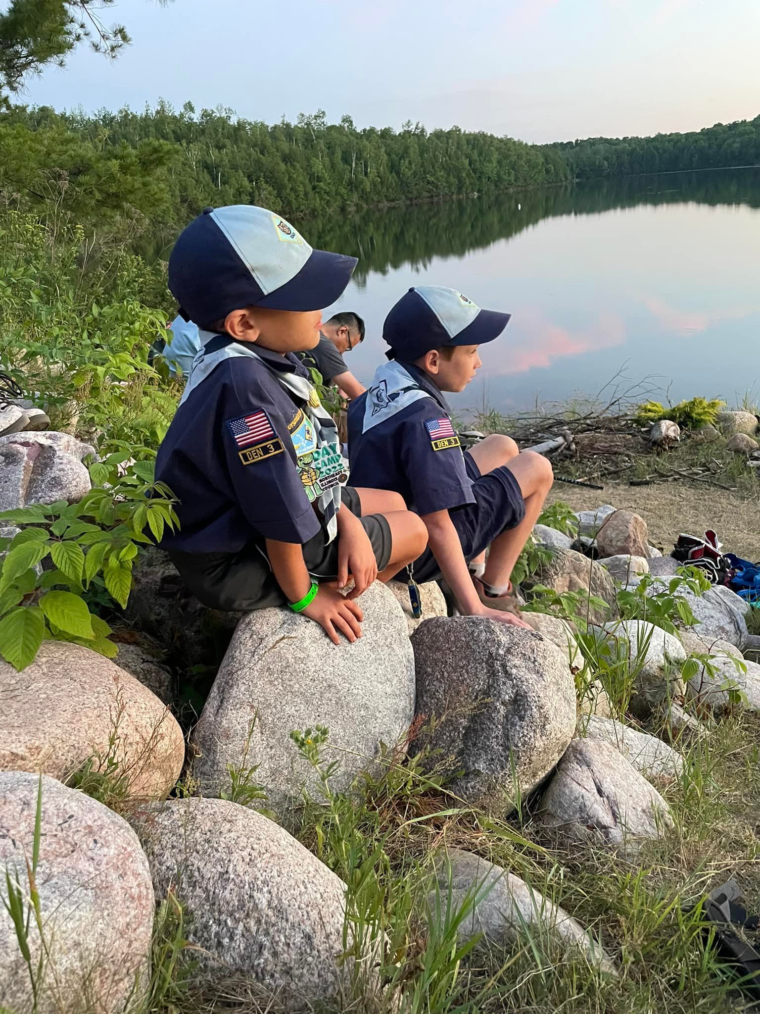 Cub Scouts Sitting on Rocks by a lake