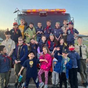 Cub Scouts sitting on a fire truck