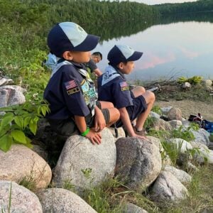 Cub Scouts Sitting on Rocks by a lake